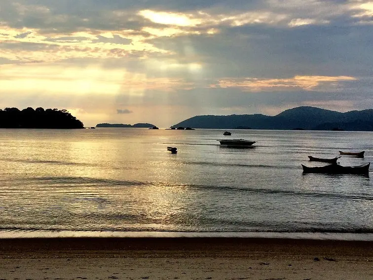 Relaxing at Jabaquara Beach as the sun begins to set over Paraty Bay.